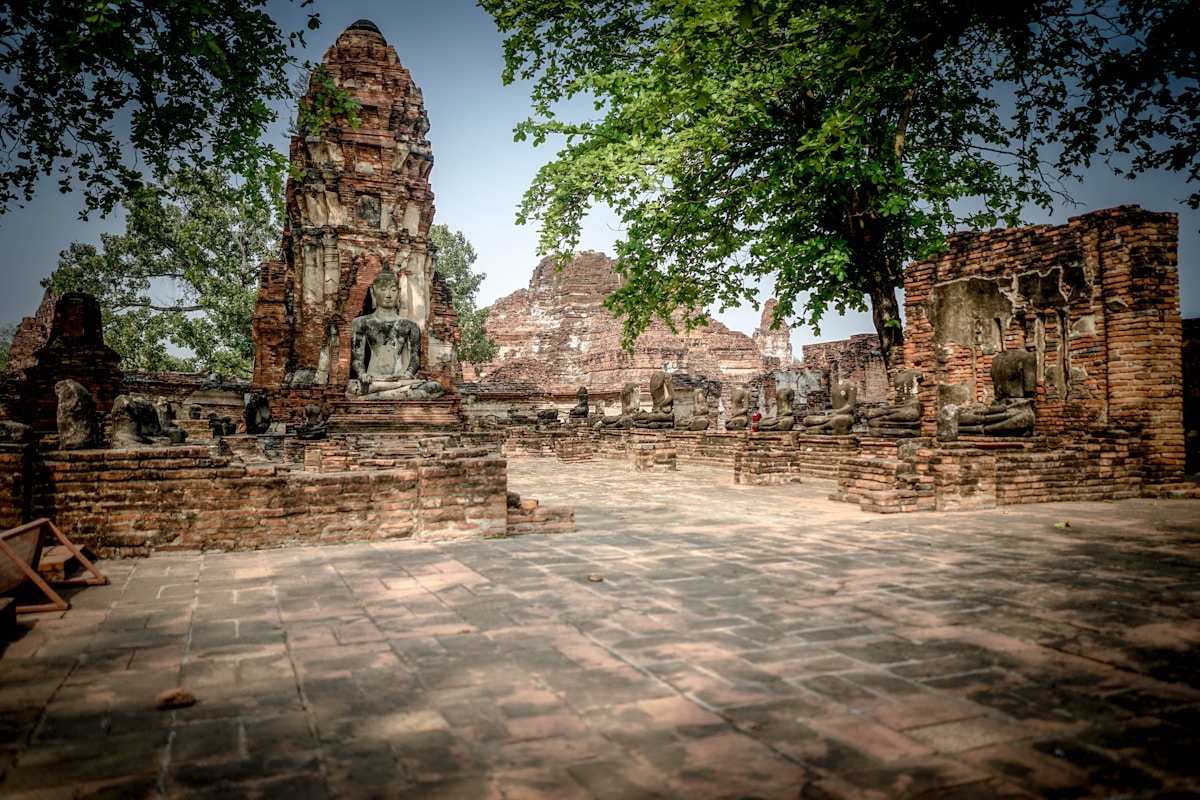 Ancient Buddha head entwined in tree roots at Wat Mahathat, Ayutthaya